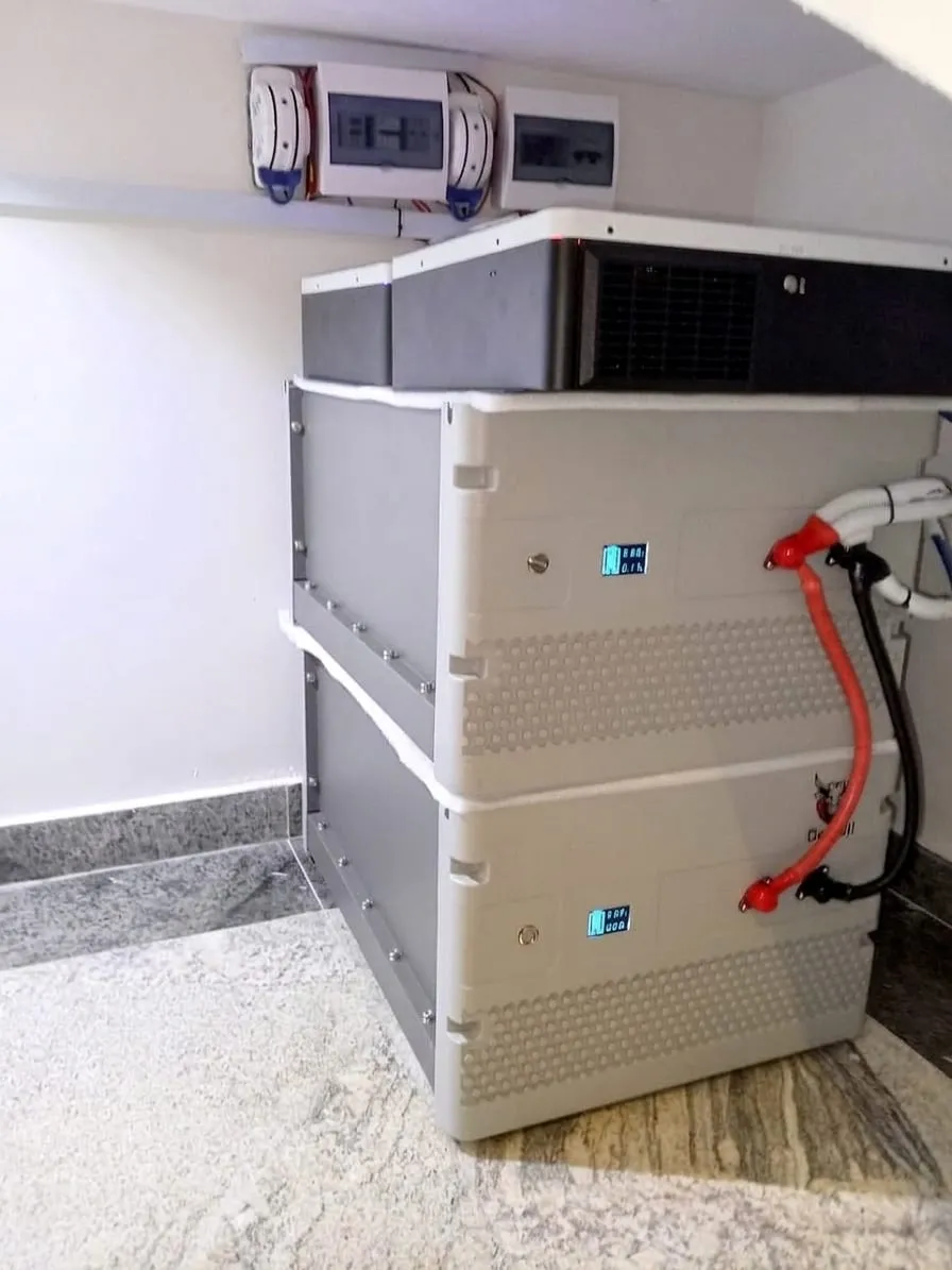 Stacked lithium battery cabinet with wall-mounted inverters and distribution boards above